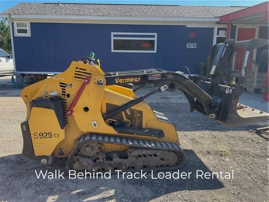 walk-behind mini skid steer with grapple bucket attachment at a rental yard in Houston, prepared for tree service and landscaping contractors in Spring, TX.